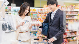 コンビニのレジで商品を選ぶ男女